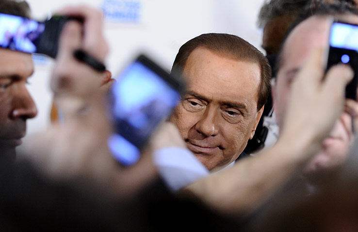 24 hours in pictures: Supporters take pictures as Italian Prime Minister Silvio Berlusconi