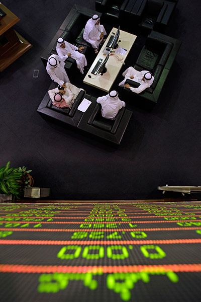 24 hours in pictures: Emirati traders under a board at board at the Dubai Financial Market