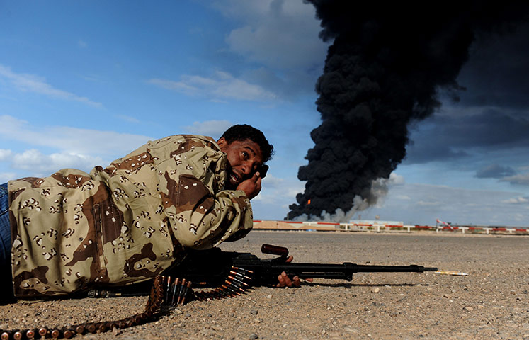 Ras Lanuf battles: A Libyan rebel fighter lies on the ground