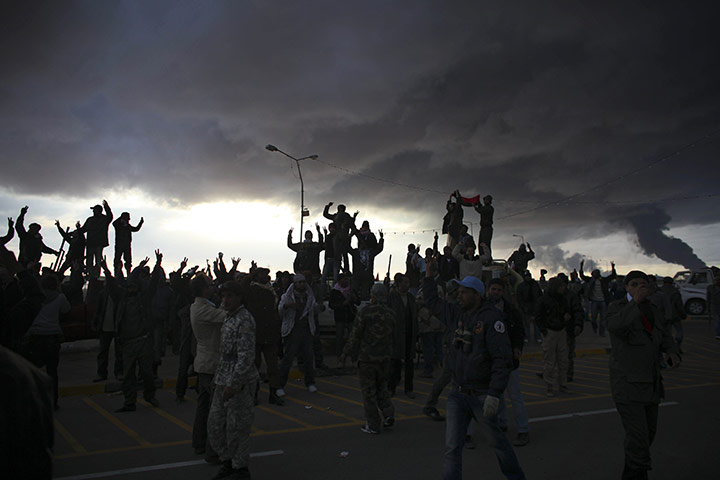 Ras Lanuf battles: Libyan volunteers cheer as smoke rises from the oil port of Sidra