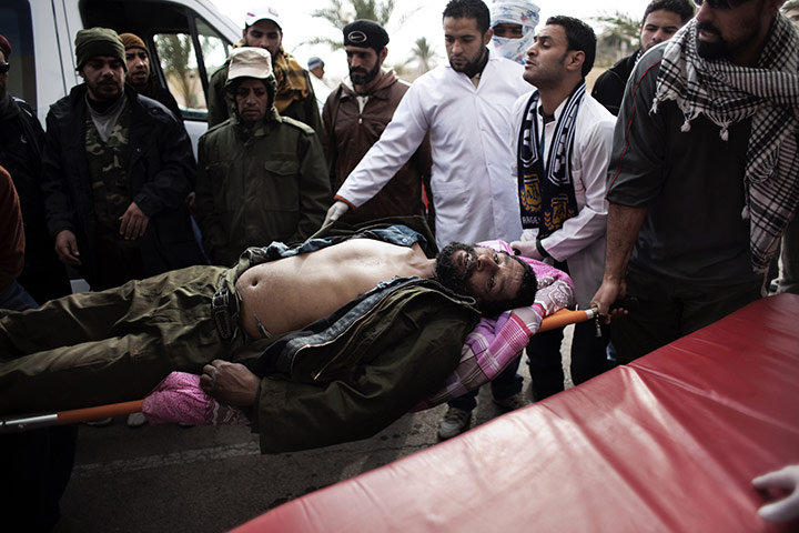 Ras Lanuf battles: A wounded Libyan rebel fighter is brought to a clinic in the Ras Lanuf