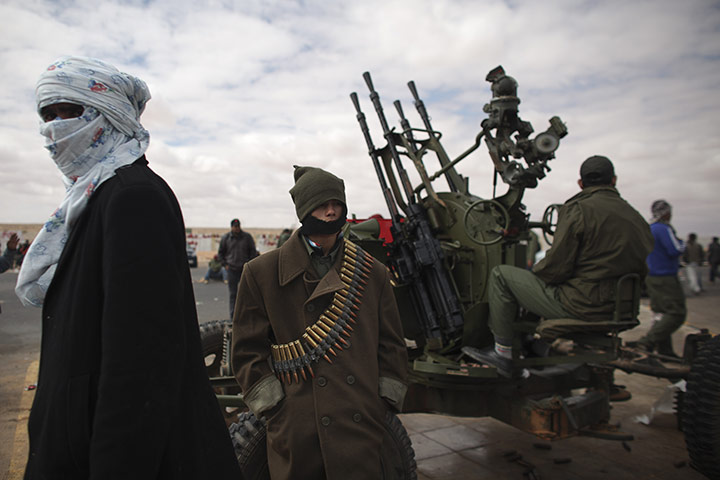 Ras Lanuf battles: Libyan volunteers sit at a checkpoint on the outskirts of Ras Lanuf