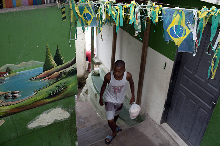 Week in business: A boy walks up an alley with small Brazilian flags 