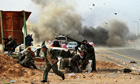 A tank shell explodes near Libyan rebels fighting Gaddafi forces in Ras Lanuf