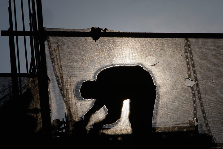 24 hours in pictures: A Bosnian construction worker is silhouetted against the su