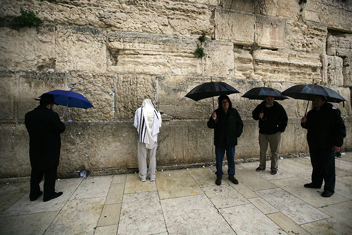 24 hours in pictures: Ultra Orthodox Jews pray during heavy rain at the Western Wall