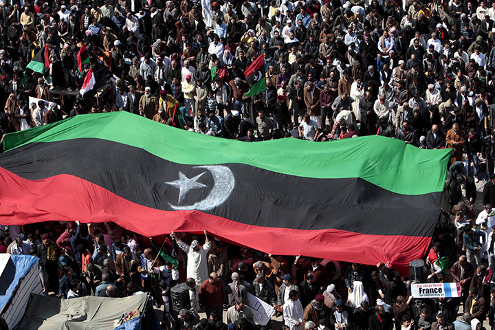 Benghazi Protests: Anti-Gadhafi protesters wave a huge pre-Gadhafi Libyan flag
