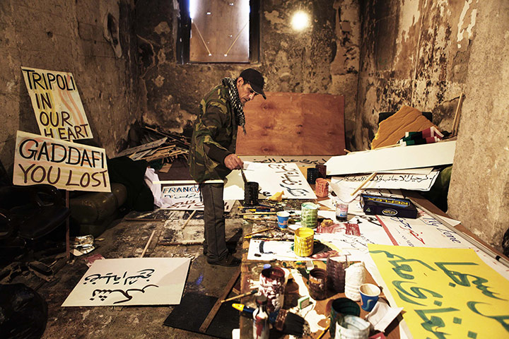 Libya unrest: a rebel fighter paints a poster