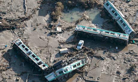 Train carriages lie overturned in Shinchi town after Japan's earthquake-triggered tsunami