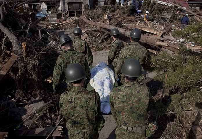 Dan Chung in Japan: Rescue workers carry away a body