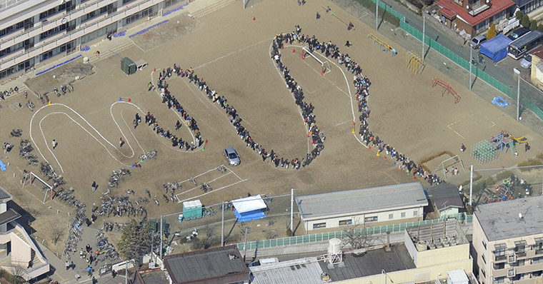 japan quake aftermath: People waiting for water in  a school in Sendai, Japan
