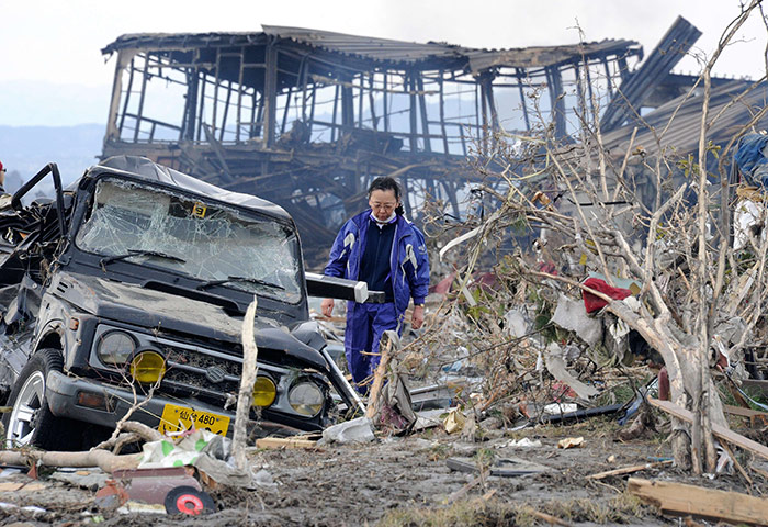 Japan tsunami rescue: A resident walks through a tsunami-devastated area in Natori