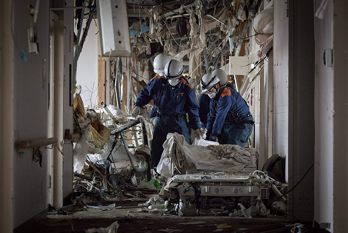 Japan tsunami rescue: Rescue workers move a patient's body at a hospital in Minamisanriku 