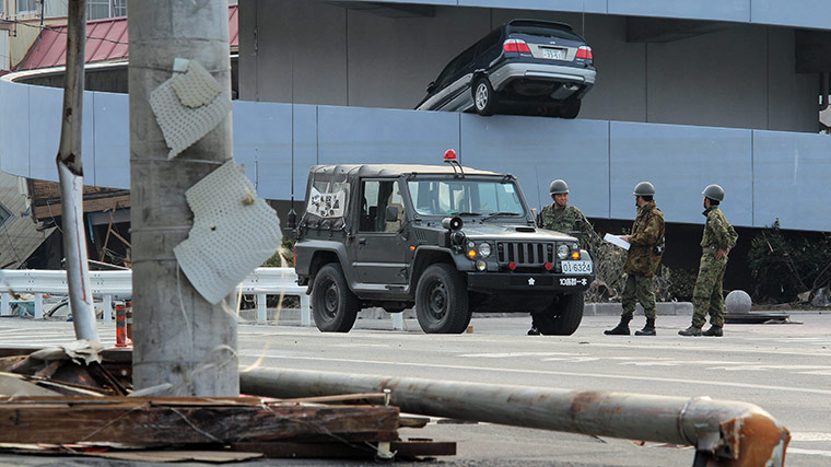Dan Chung in Japan: Japan Self-Defence Force troops in front of a car swept up by a tsunami