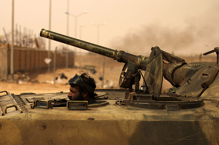 Libya, Ajdabiya: A Libyan rebel drives his tank to the frontline in Ajdabiya