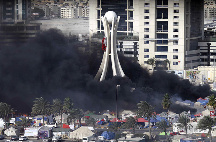 Bahrain uprising: Black smoke billows from burning tents in Pearl Square in Manama