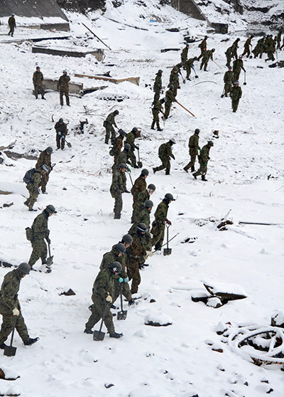 japan disatster: Japan's Self Defence Force soldiers search for survivors in the snow