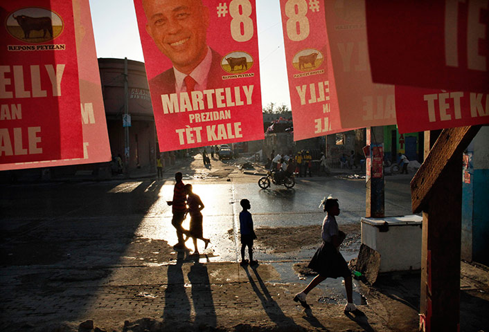 24 hours in pictures: Haitians walk past posters of presidential candidate, Port-au-Prince
