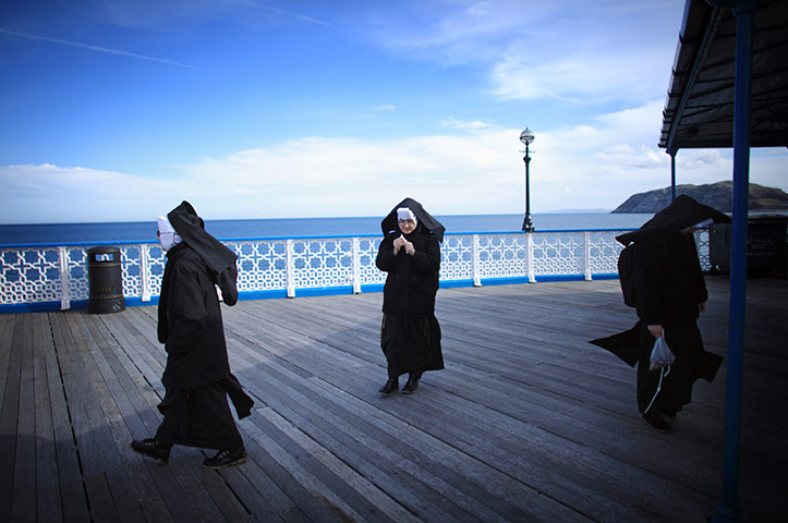 24 hours in pictures: Nuns enjoy a bracing walk along the wooden boardwalk of Llandudno Pier