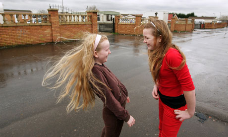Two young girls share a joke