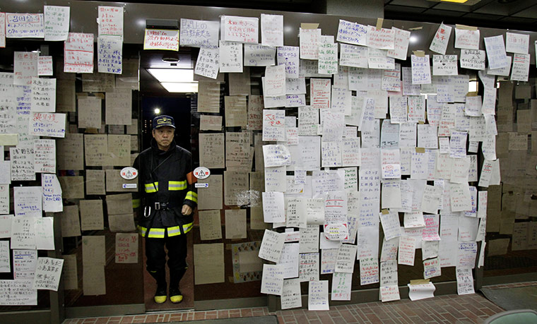 Japan aftermath: Survivors' notes seeking information about missing relatives and friends hang on the entrance of Natori city hall