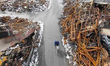 A man rides a bicycle at an area hit by earthquake and tsunami in Kesennuma, Japan