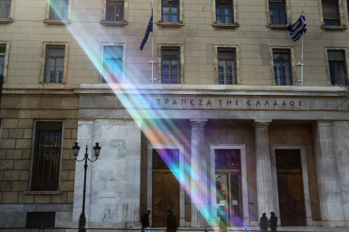 Week in Business: Pedestrians walk past the HQ of the Central Bank of Greece in Athens