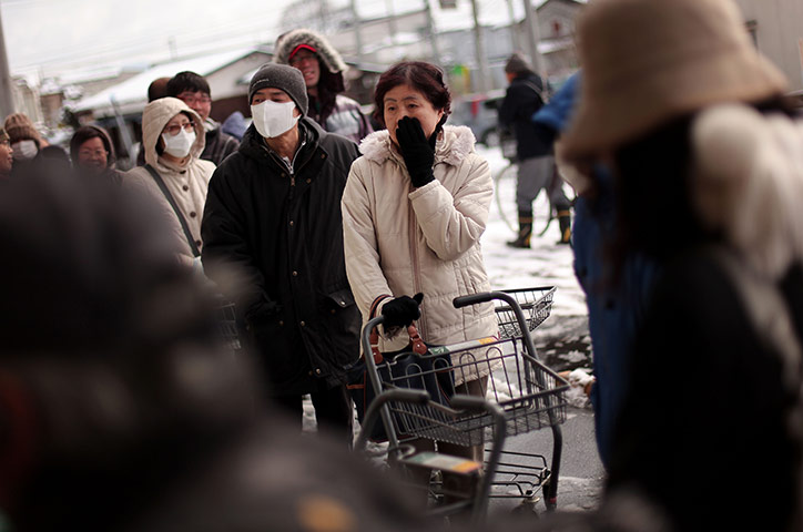 Japan aftermath: A woman waits in a line outside a grocery store in Ichinoseki