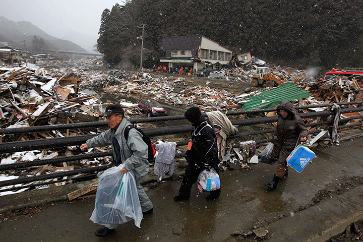 Japan aftermath: People walk from their damaged house in Kamaishi, Japan