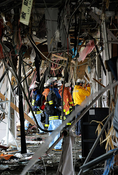 Japan Earthquake: Rescue workers search for victims amid debris at a hospital Minamisanriku