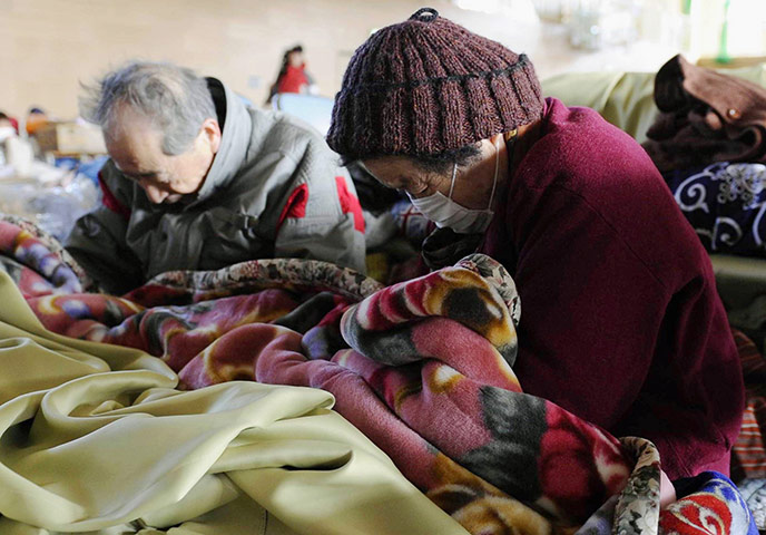 Japan Earthquake: An elderly couple observe a moments silence Rikuaentakata Iwate Prefecture