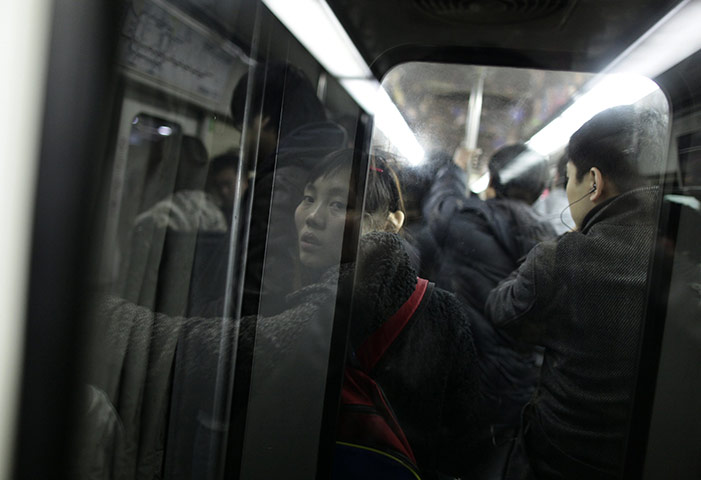 24 hours in pictures: A passenger is reflected on a crowded subway train in Beijing