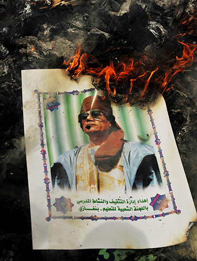 Libya: A portrait of Gaddafi burns with hundreds of copies of his 'green book'