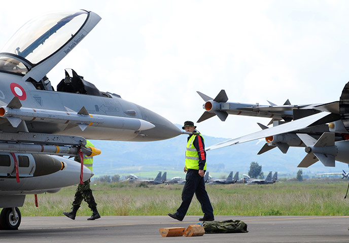 Libya airstrikes: A technician inspects missiles mounted on of one of six Danish F16 fighters