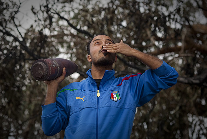 Libya airstrikes: A Libyan rebel celebrates with a rocket in the outskirts of Benghazi
