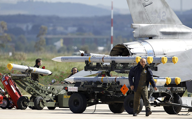 Libya airstrikes: Ground crew transport weapons for an Italian F-16 Fighting Falcon