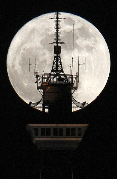 Super moon: Berlin, Germany: Behind the top of the Funkturm radio and television tower