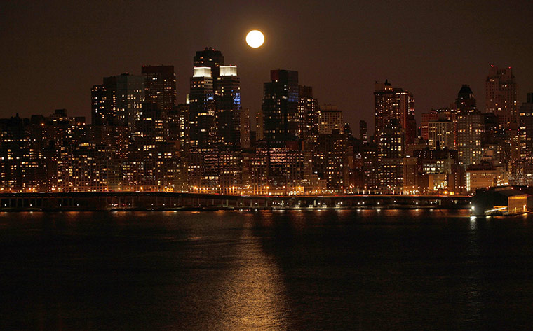 Super moon: A full moon rises over the skyline of Manhattan along the Hudson River 