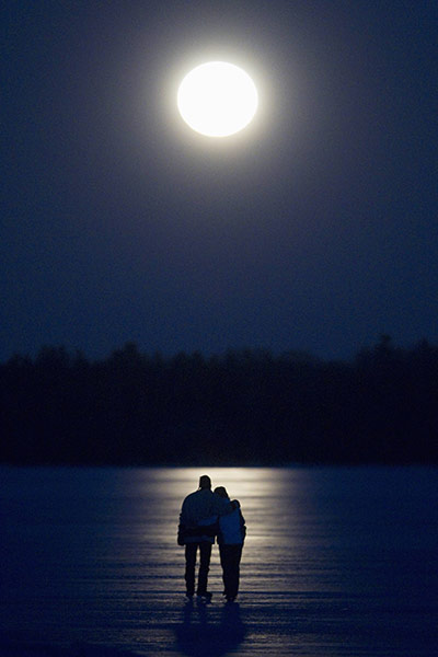 Super moon: A couple skate under a full moon on Pigeon Lake near Bobcayeon, Ontario