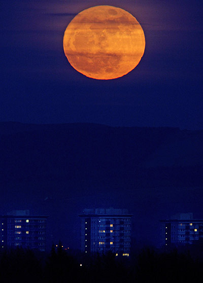 Super moon: The moon  rises from behind the hills of the Peak District