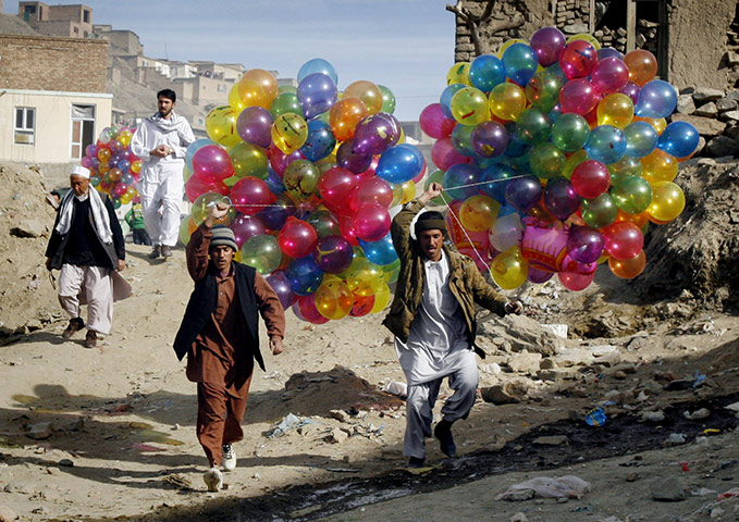Spring festivals: Afghans carry balloons to sell as they walk towards the Sakhi Shrine