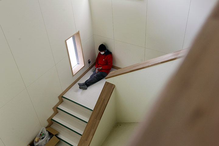 Japan aftermath continues: Survivor charges his phone at an evacuation centre, Japam