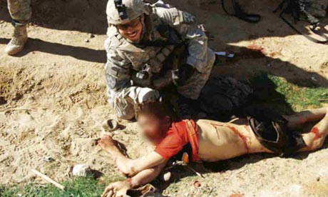 A US soldier poses with dead civilian in Afghanistan