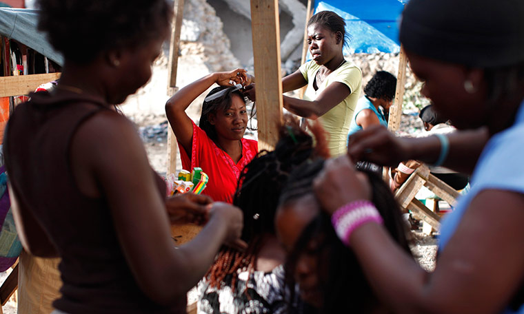 24 hours in pictures: A woman gets hair extensions in downtown Port-au-Prince