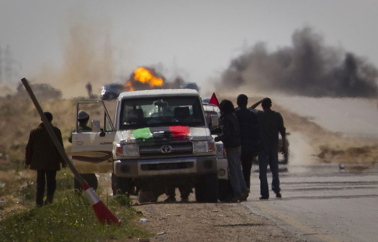 Libya battles: Libyan rebels stop on the road as mortars are fired by Gaddafi's forces