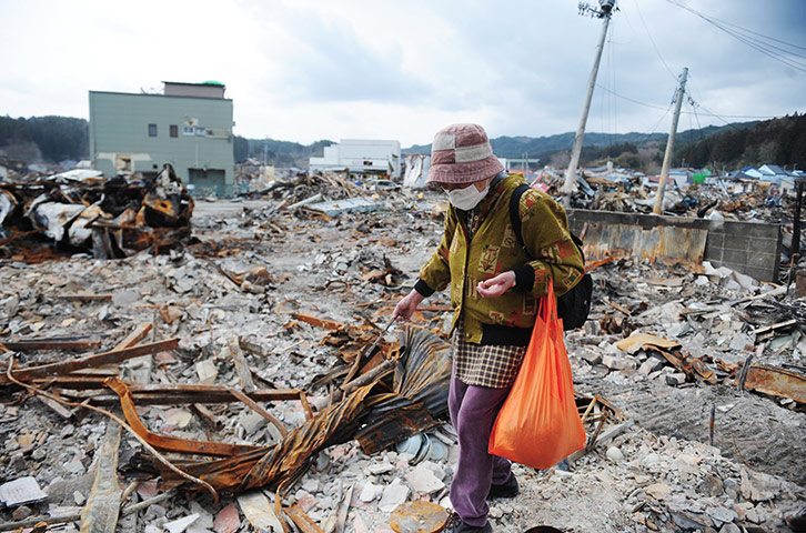 Japan salvage: A woman lingers at the site her home was once located in Iwate