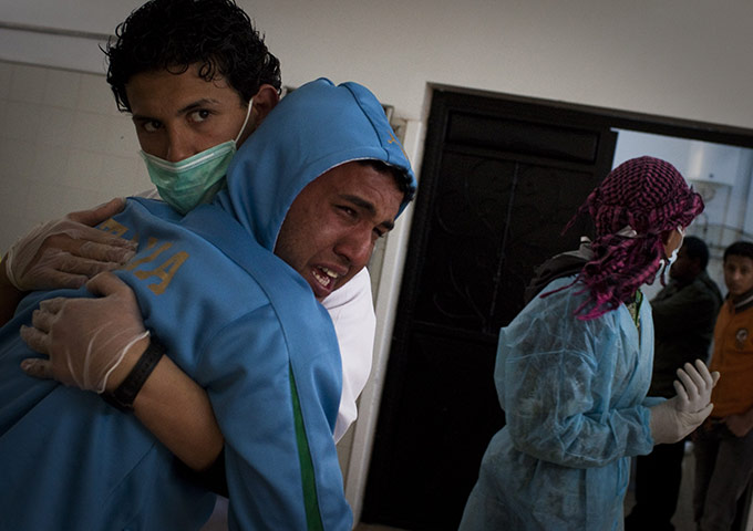 Libya chaos: A Libyan man is comforted by hospital staff after he identified his brother