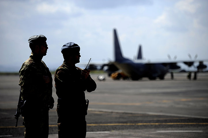 Libya chaos: Italian soldiers look at an Hercules C130 at Sigonella military airport