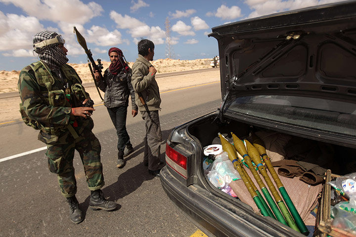 Libya chaos: Libyan rebels unload rocket propelled grenades from a car
