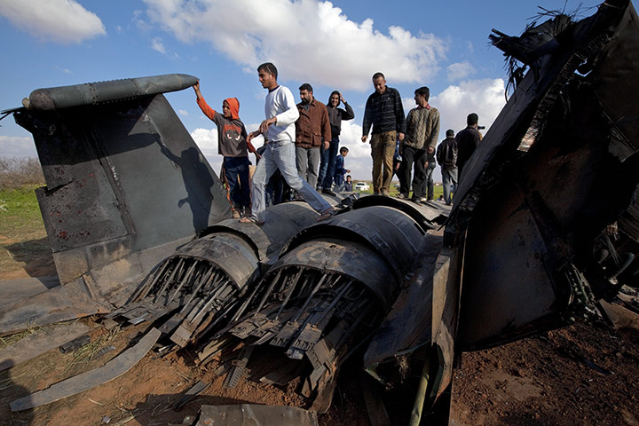 Libya chaos: Libyans inspect the remains of a US F-15E Strike Eagle fighter jet